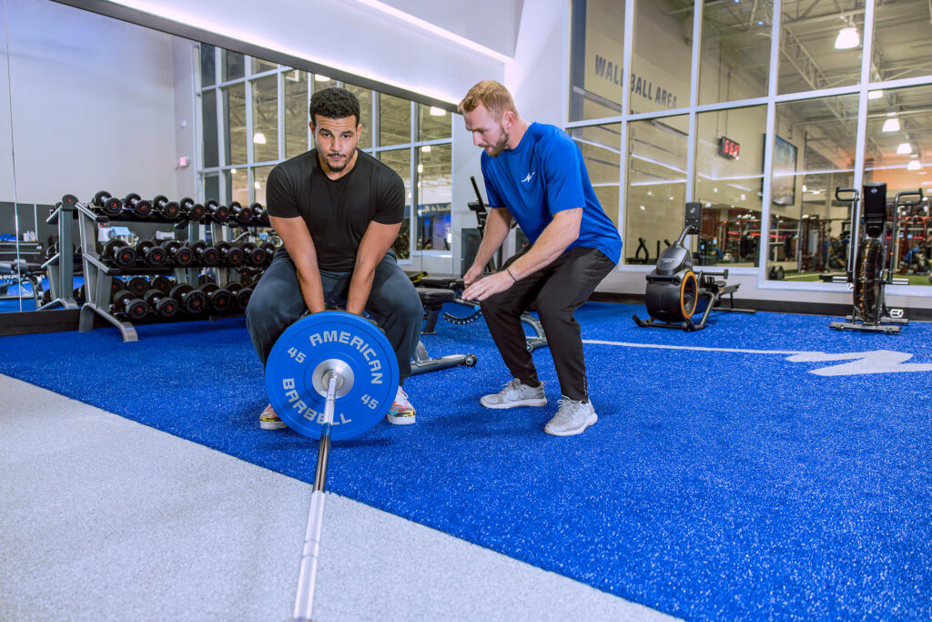Man working out with Personal trainer at Club Fitness Man working out with Personal trainer at Club Fitness
